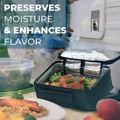 A black insulated lunch bag with a silver foil-lined interior sits open on a table, containing a meal with broccoli and chicken. A clear plastic container of salad is blurred in the background, with a plate of food in the foreground.