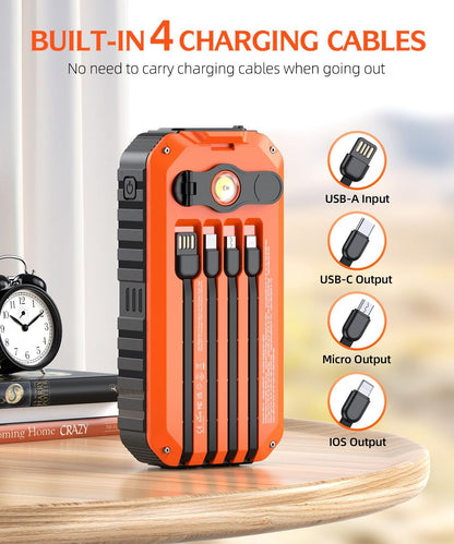Orange and black power bank with built-in charging cables on a wooden surface.
