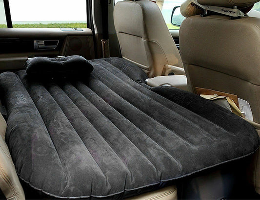 Inflatable mattress in a car's back seat with a pillow on top