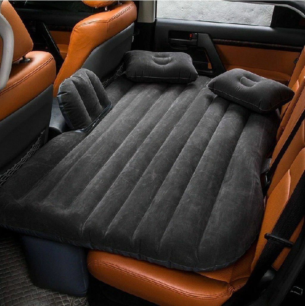 Inflatable mattress set up in a car with brown leather seats.